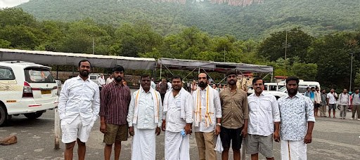 Happy customers in traditional wear at a hillside halt, with our vehicles waiting for the drive ahead.